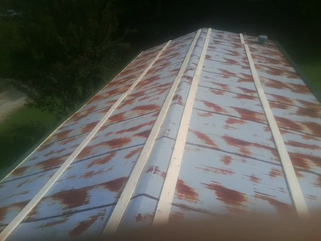 Rusted metal roof panels with new wood purlins before replacement — Storm Damage Roof Repair in Tobaccoville by Roofing Brothers