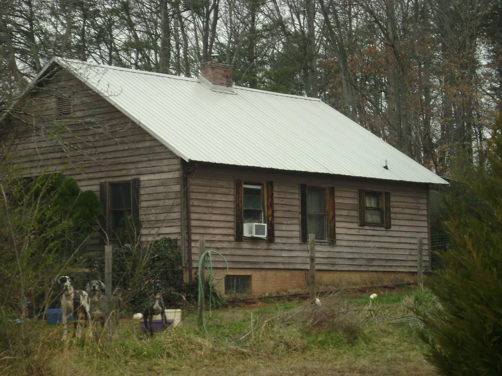 White metal roof on an old wood sided farmhouse, from a Metal Roof Installation job in Tobaccoville